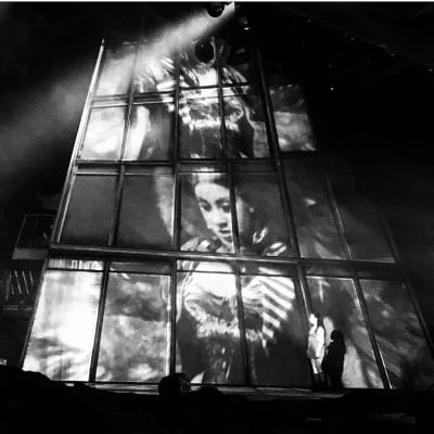 Photo from the set of Bat Out Of Hell, showing Danielle Steers as Zahara, projected onto the side of Falco Tower 