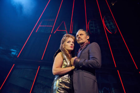 Scene from Bat Out Of Hell The Musical : Sloane (Sharon Sexton) and Falco (Rob Foster) in front of Falco Tower