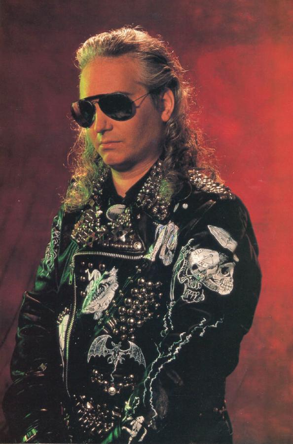 Photo of Jim Steinman (late-1980s) wearing sunglasses and black leather jacket decorated with chrome studs and pictures of skulls, bats, etc