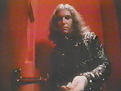 Jim Steinman : still taken from Dance In My Pants music video. Jim handles coins to insert into a coin-operated device